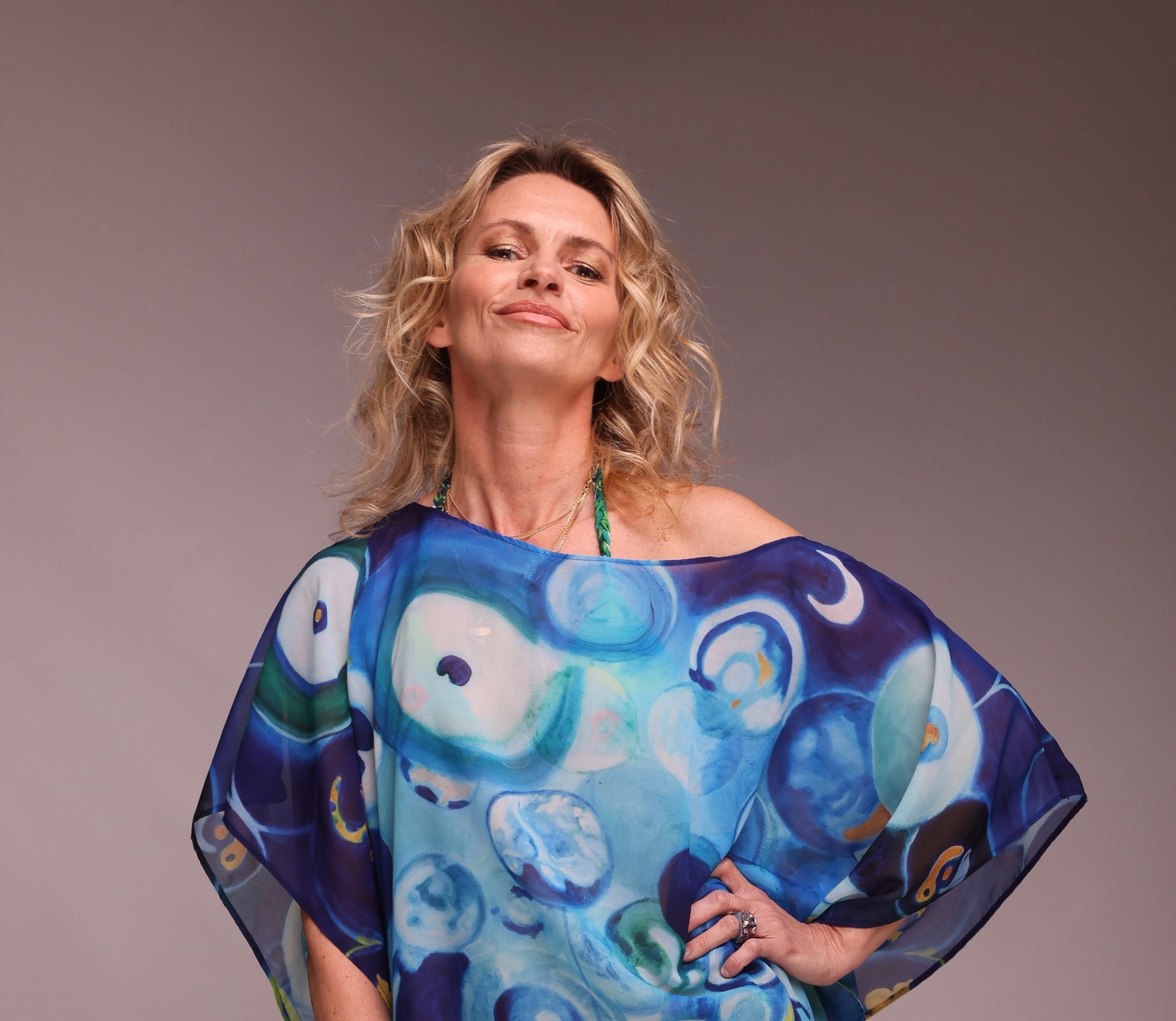 Sandra Czich, self-taught artist and founder of CZI wears the Mykonos Blue poncho created from one of its paintings 